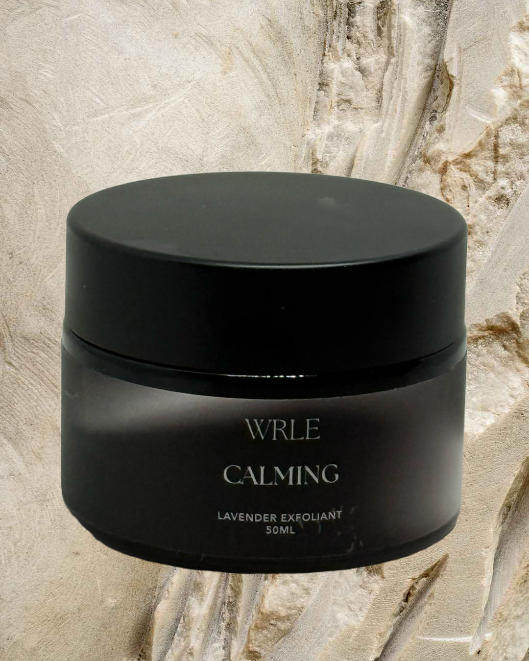 Black jar labeled 'WRLE Calming' on a marble background